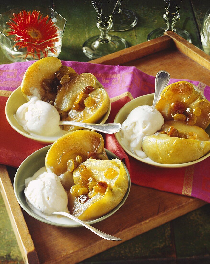 Three Bowls of Baked Apples with Raisins and Vanilla Ice Cream on a Tray