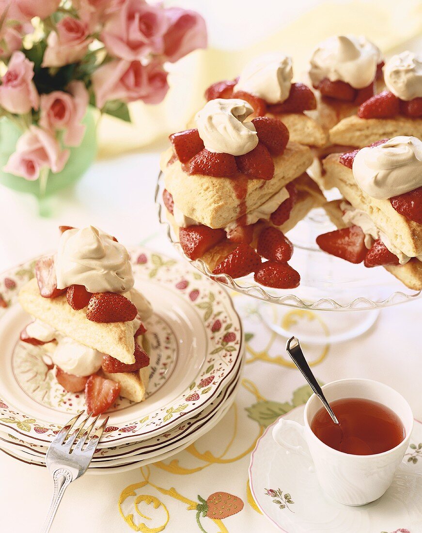 Strawberry Shortcakes on a Cake Plate and One on a Dish; Cup of Tea