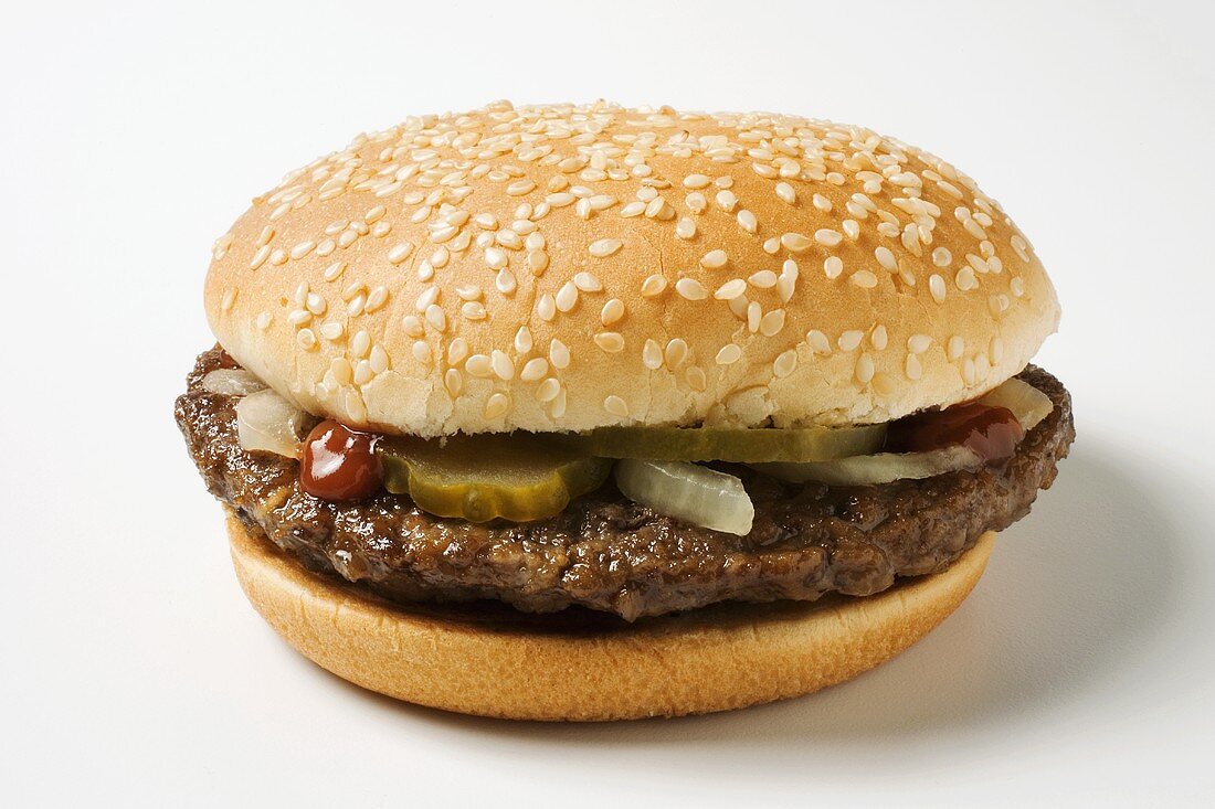 A Hamburger with Pickles, Onions and Ketchup on a Sesame Seed Bun