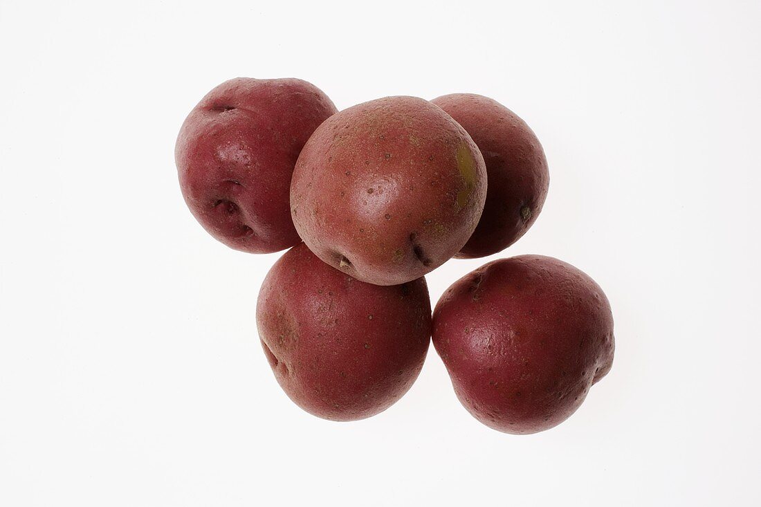 Several red potatoes on white background