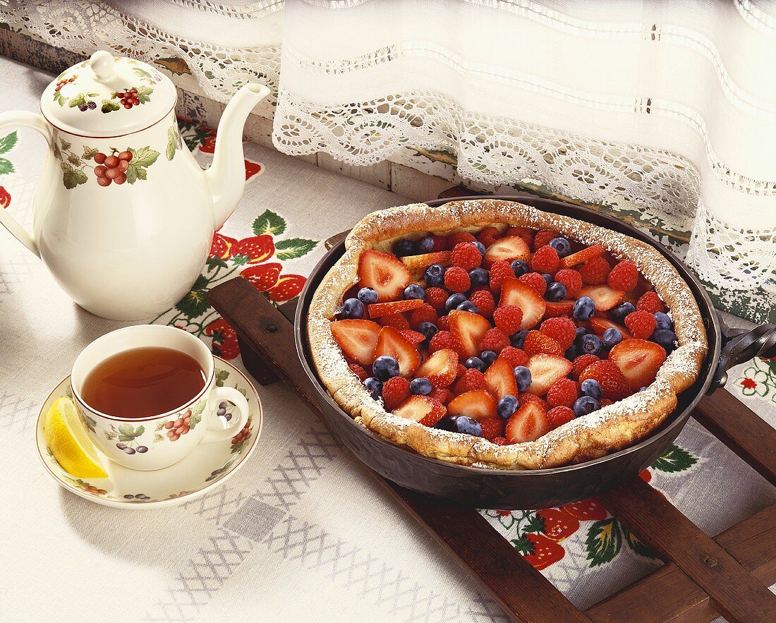 Strawberry and Blueberry Plantation Skillet Cake in Skillet; Cup and Pot of Tea