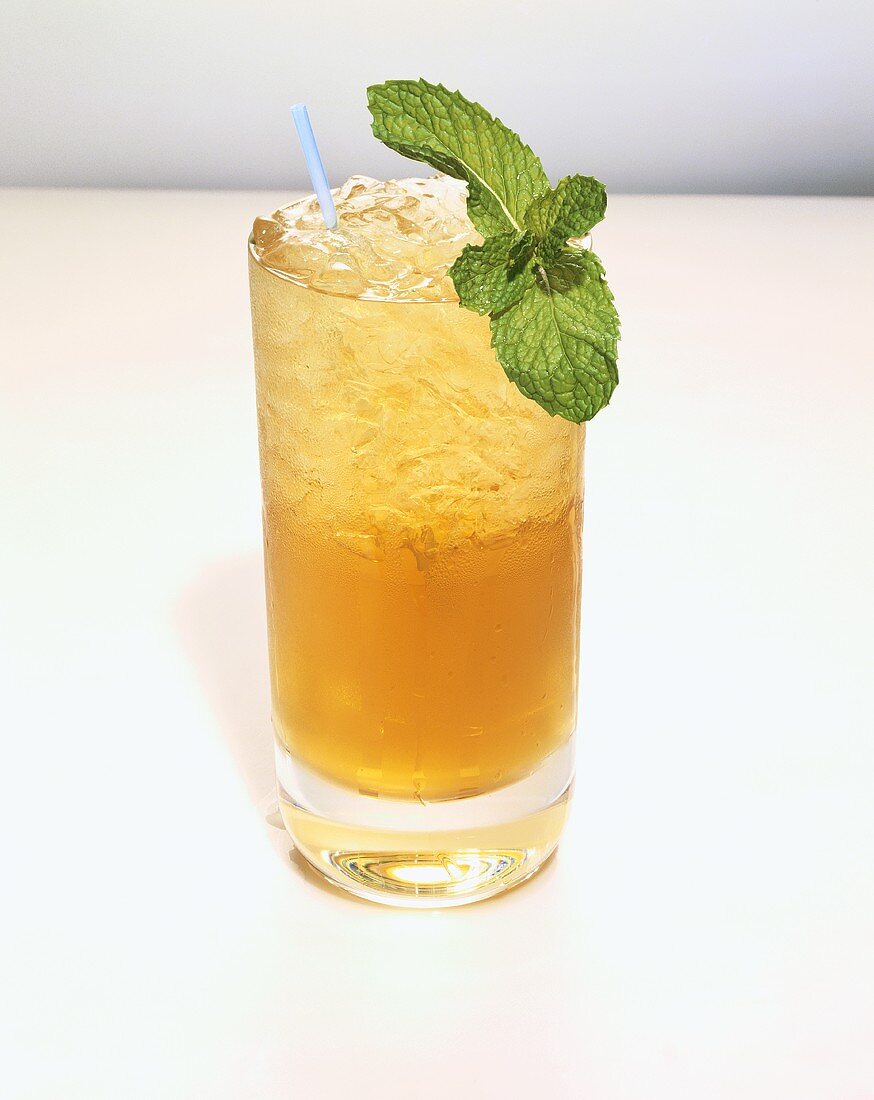 Glass of Mint Julep on the Rocks with a Straw and Mint Garnish