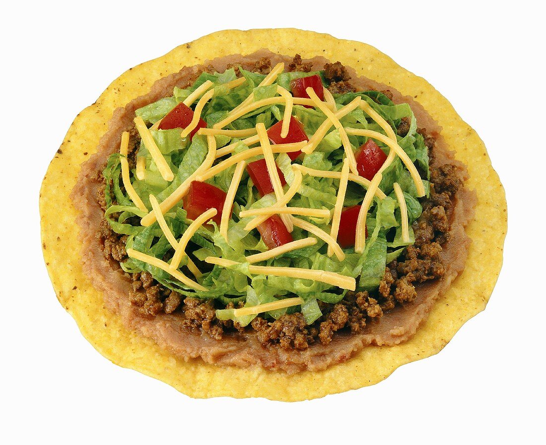 Tostada with beef, bean puree, lettuce, tomatoes & cheese