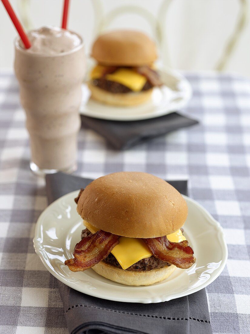 Two Bacon Cheeseburgers and a Milkshake with Two Straws in Diner