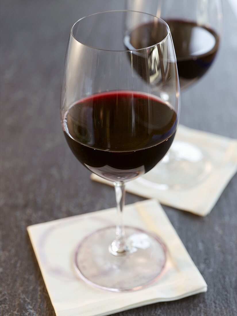 Two Glasses of Red Wine on White Cocktail Napkins