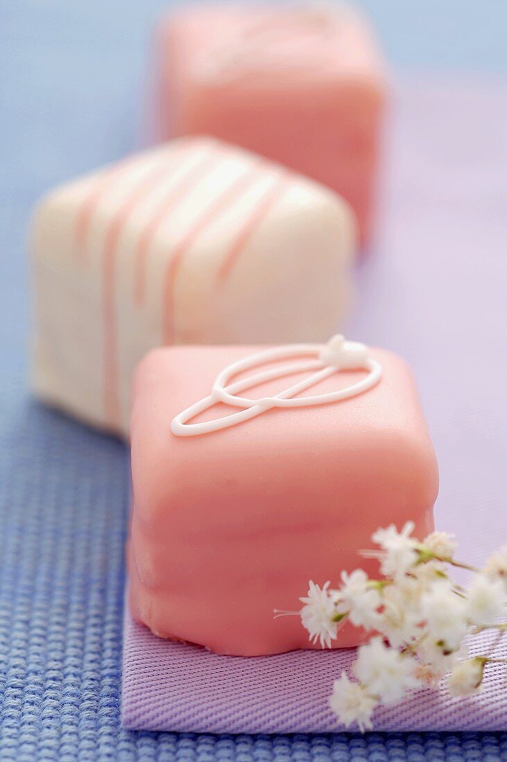 Pretty Pink and White Petits Fours with Small White Flowers