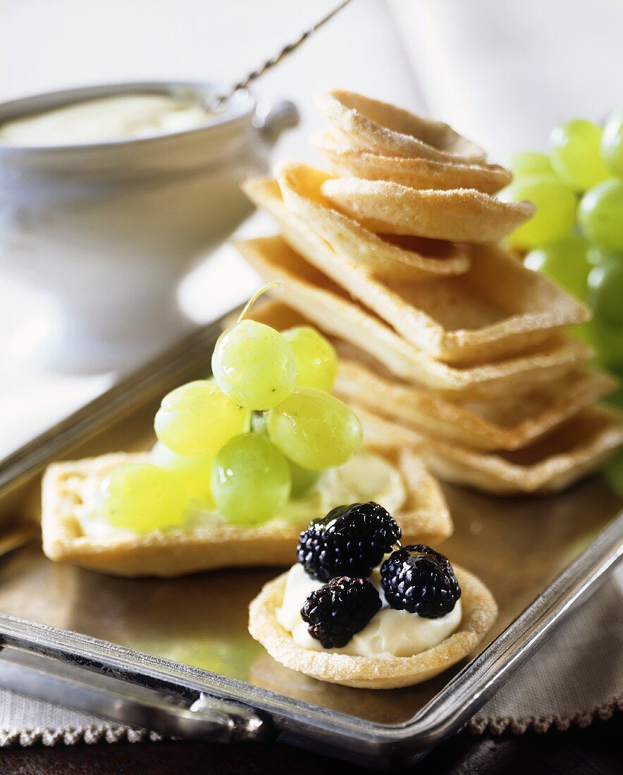 Tart cases filled with soft cheese, blackberries & grapes