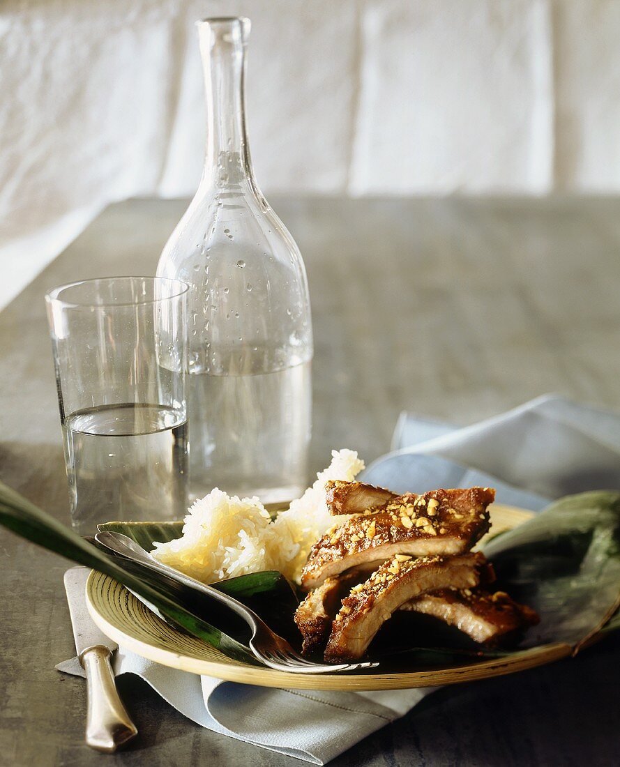 Grilled pork ribs with peanut crust, rice and water