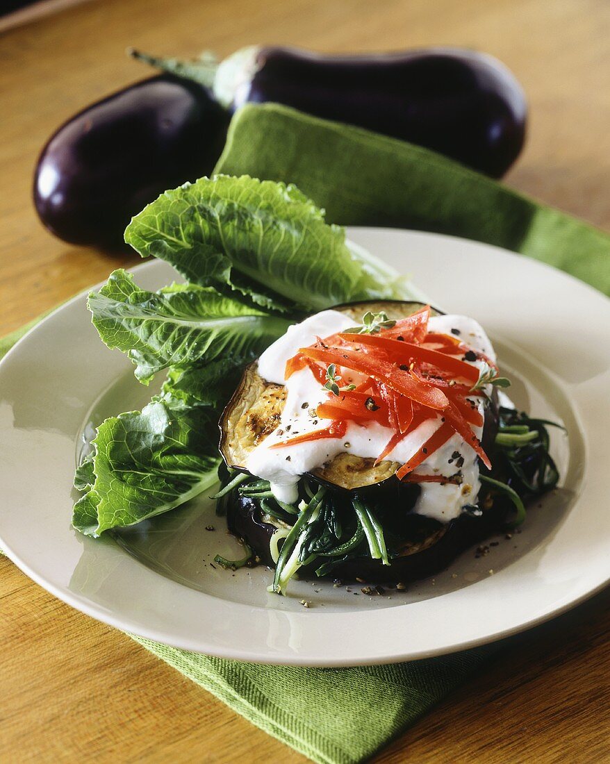 Aubergine on spinach with sour cream