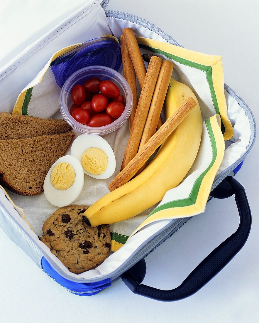 Lunchbox mit Banane, Cookie, Ei, Brot etc.
