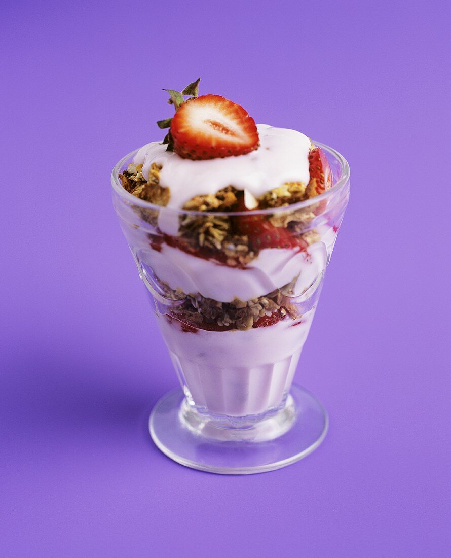 Layered dessert with yoghurt cream, crumble and strawberries