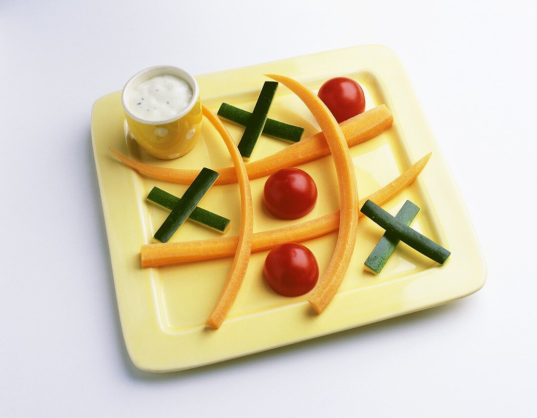 Vegetable sticks, tomatoes & yoghurt dip as Noughts and Crosses 