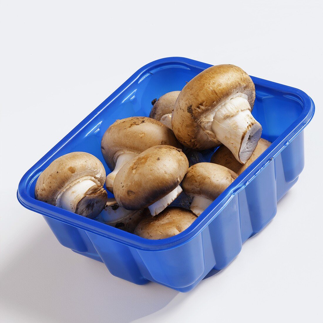 Chestnut mushrooms in blue plastic punnet