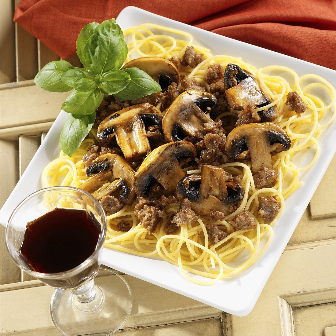 Spaghetti Topped with a Sausage and Mushroom Sauce with Basil Garnish, Red Wine