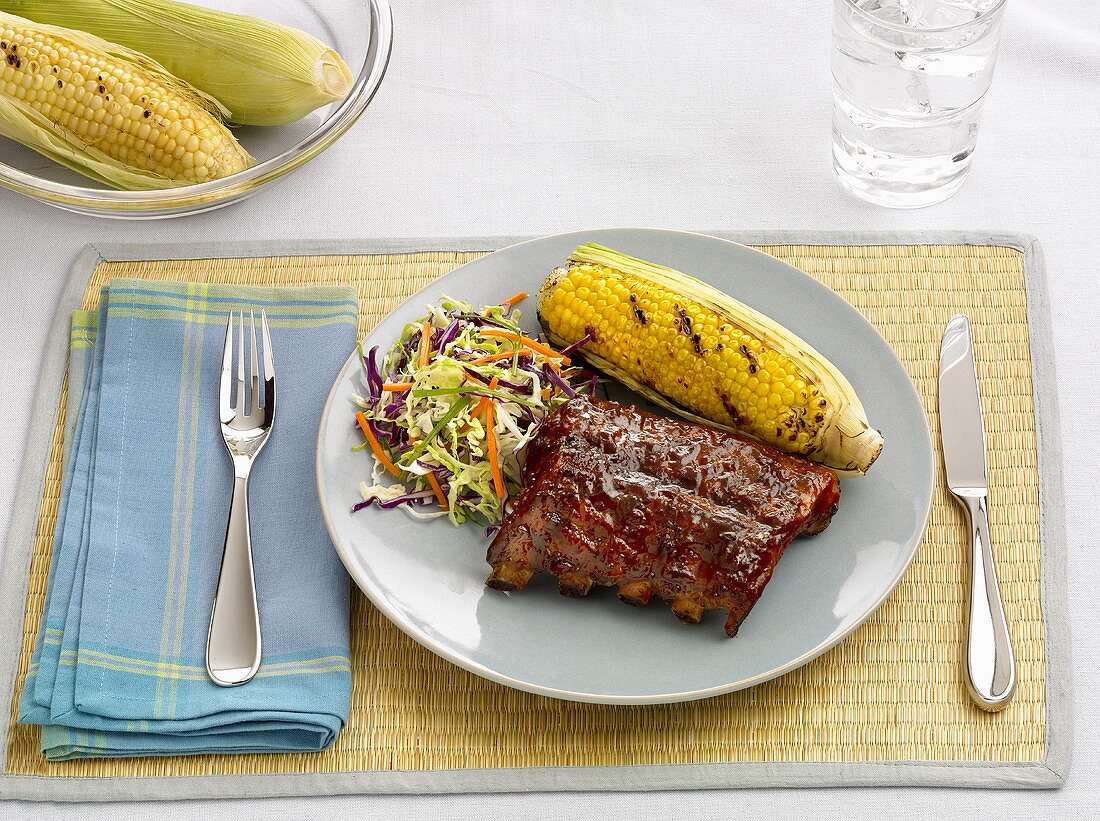 Grilled spare ribs, corn on the cob and cabbage salad
