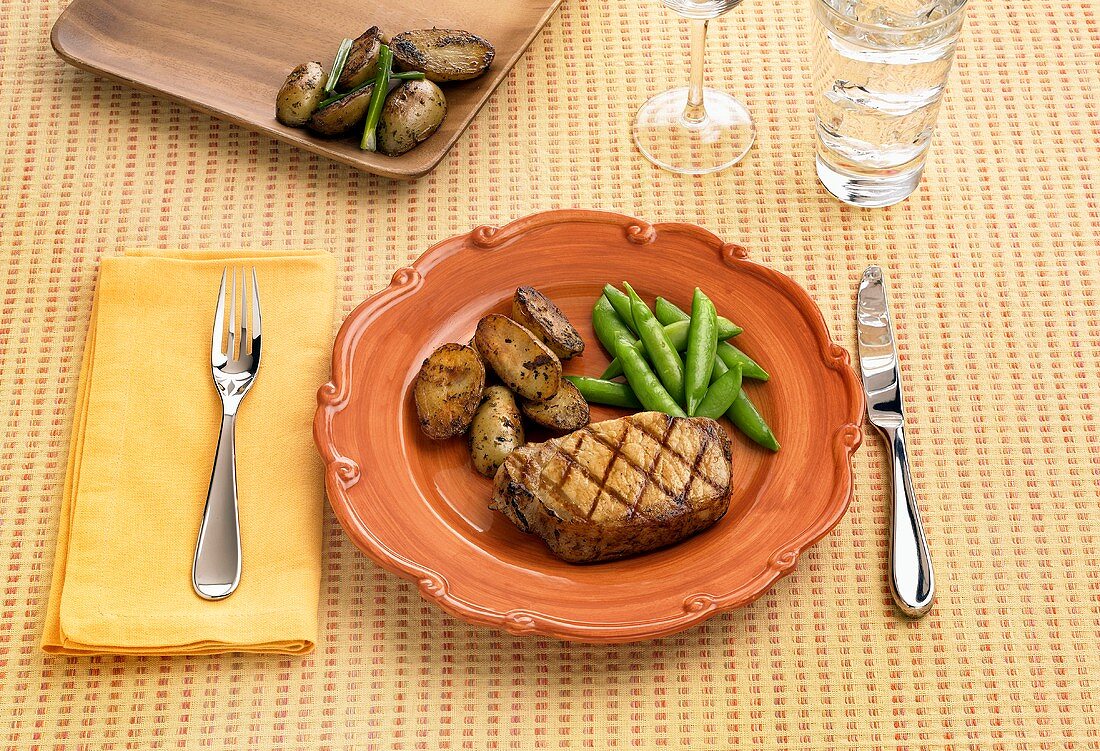 Place Setting with Grilled Boneless Pork Chop with Potatoes and Snap Peas