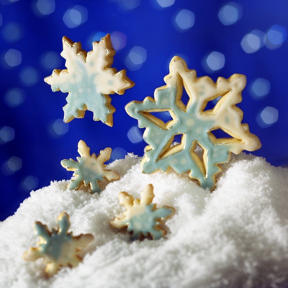 Plätzchen als Schneekristalle mit weisser und blauer Glasur