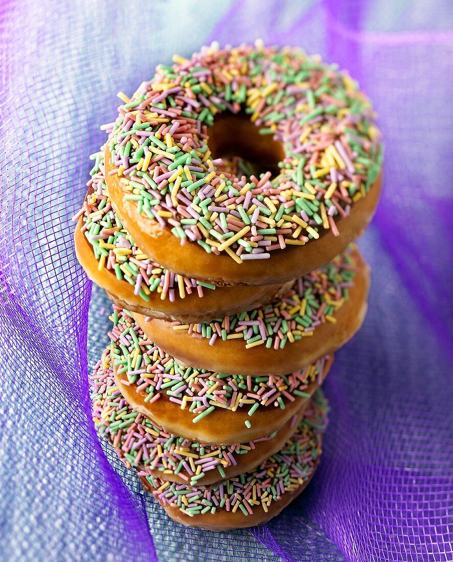 Six Glazed Donuts with Sprinkles Stacked on Each Other