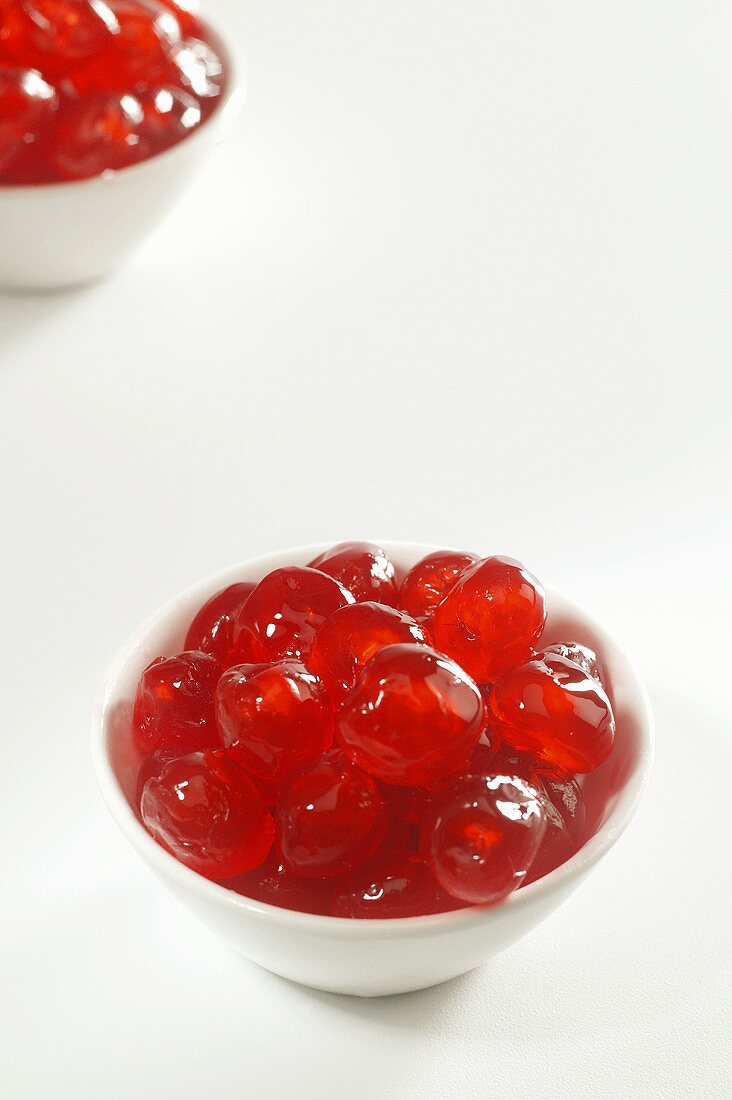 Two Bowls of Candied Red Cherries on White