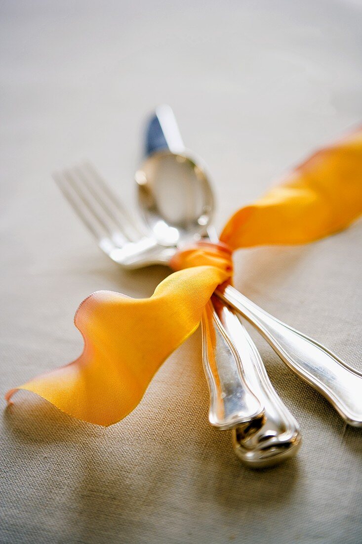 Cutlery tied together with orange ribbon