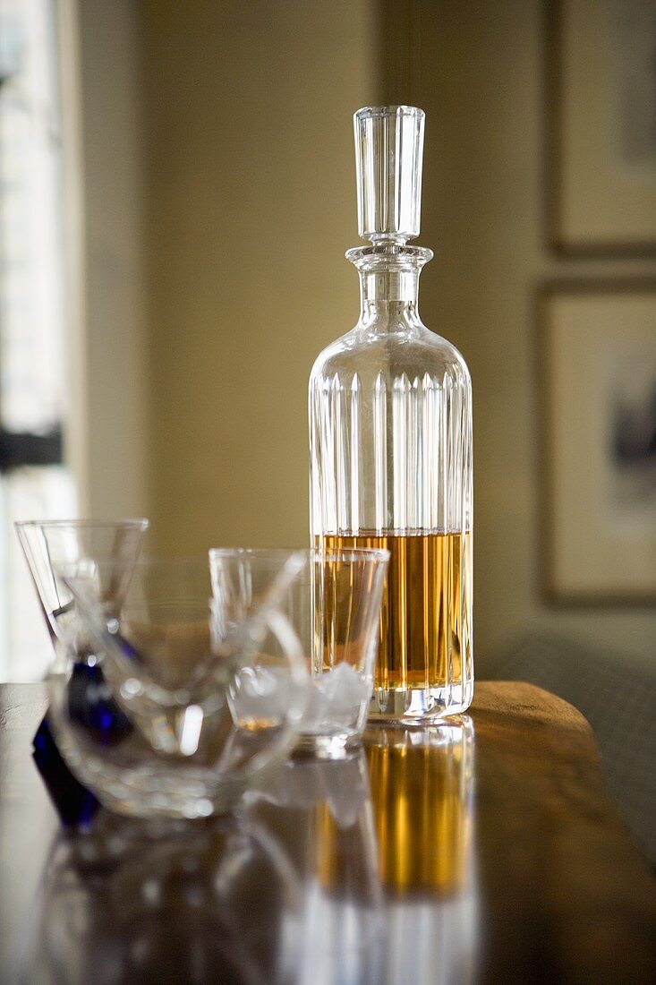 Whiskey in Karaffe und leeres Glas auf Tisch