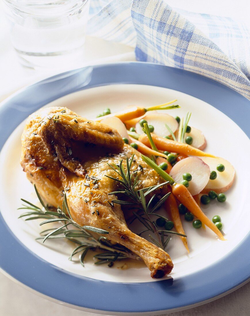 Roasted Half Chicken with Rosemary on a Plate with Potatoes, Carrots and Peas