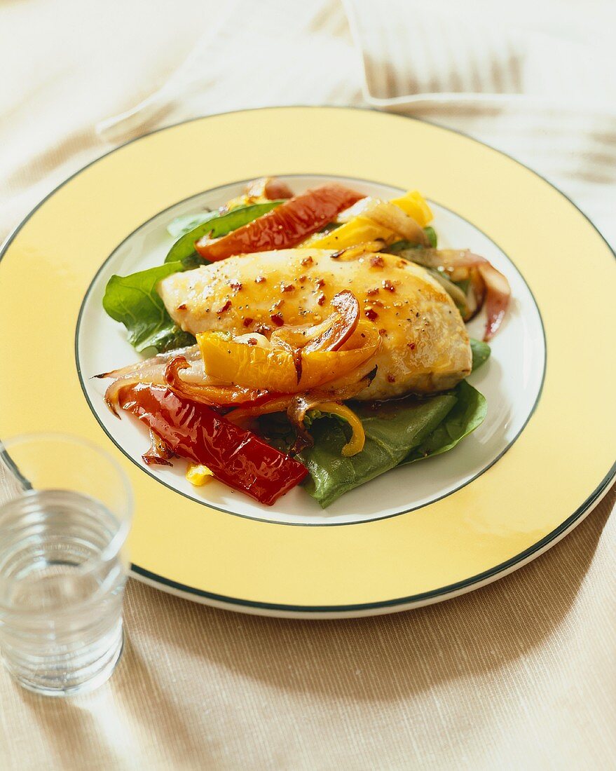 Glazed Chicken Breast with Tri-Colored Bell Peppers on a Plate, Glass of Water
