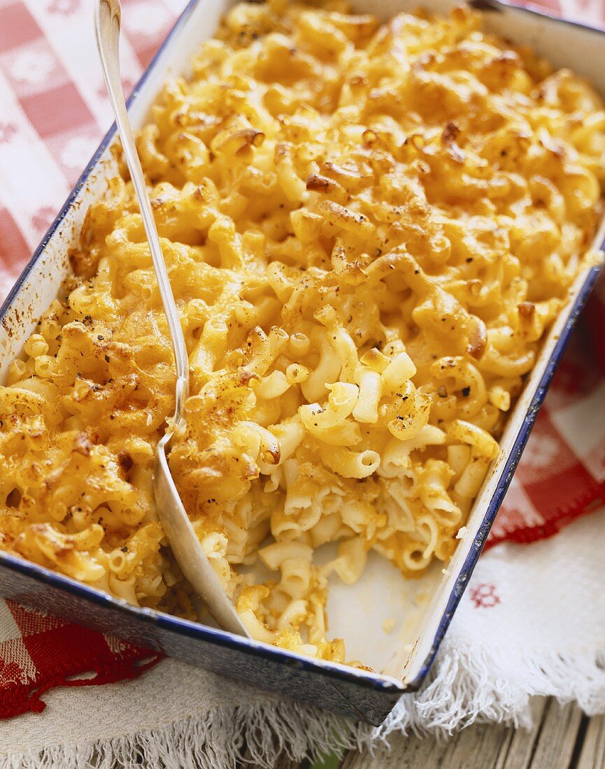 Baked Macaroni and Cheese in a Casserole Dish with Scoop Removed, Serving Spoon