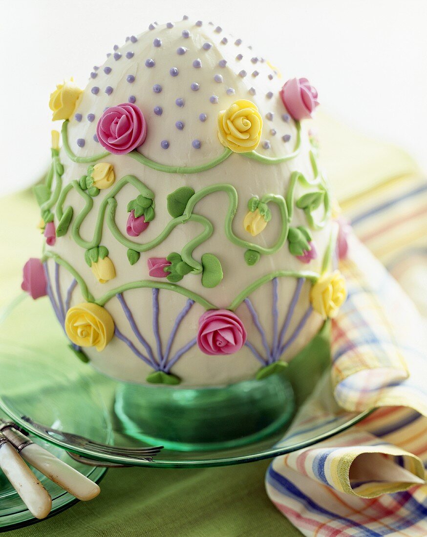 Torte in Ostereiform mit Rosen aus Zuckerguss dekoriert