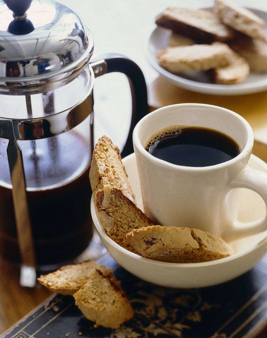 Cup of Coffee on Saucer with Biscotti; Percolator and Plate of Biscotti
