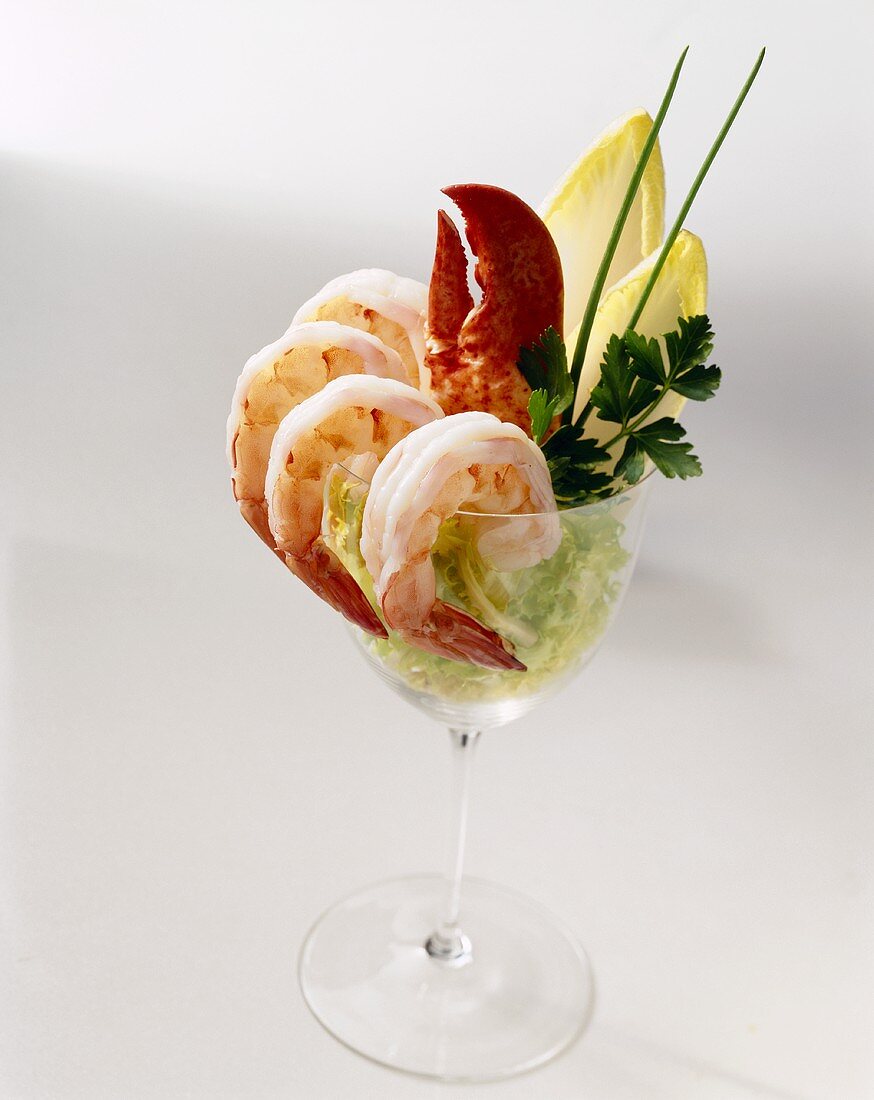 Shrimp Cocktail with a Lobster Claw in a Stem Glass with Greens; White Background