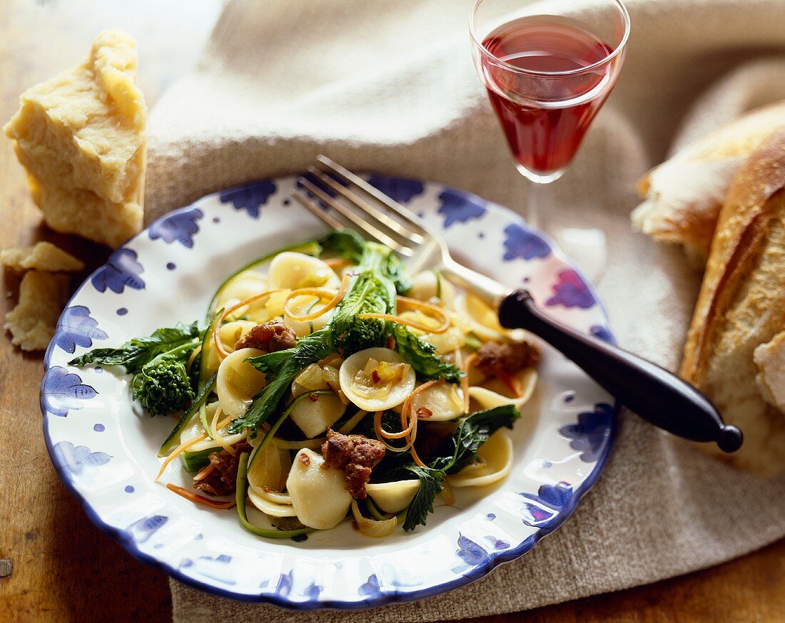 Orrecchietti Pasta with Sausage and Broccoli Rabe on a Plate with Fork; Glass of Wine