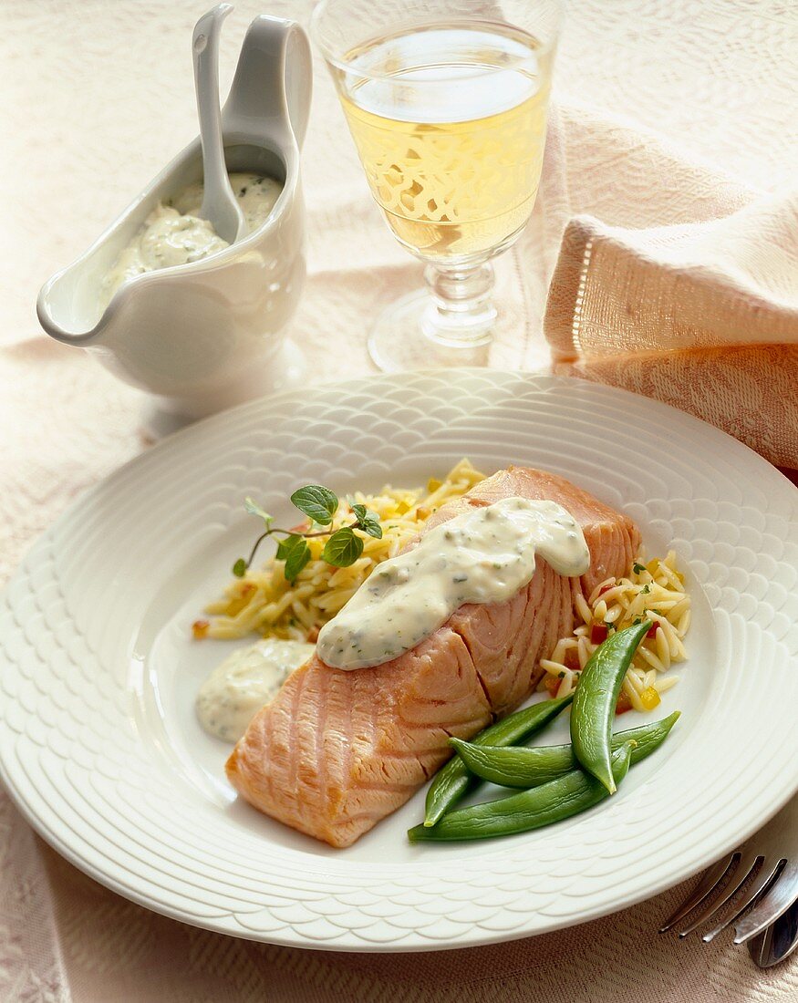 Poached Salmon Topped with Cream Sauce Served with Snap Peas and Rice; Glass of White Wine