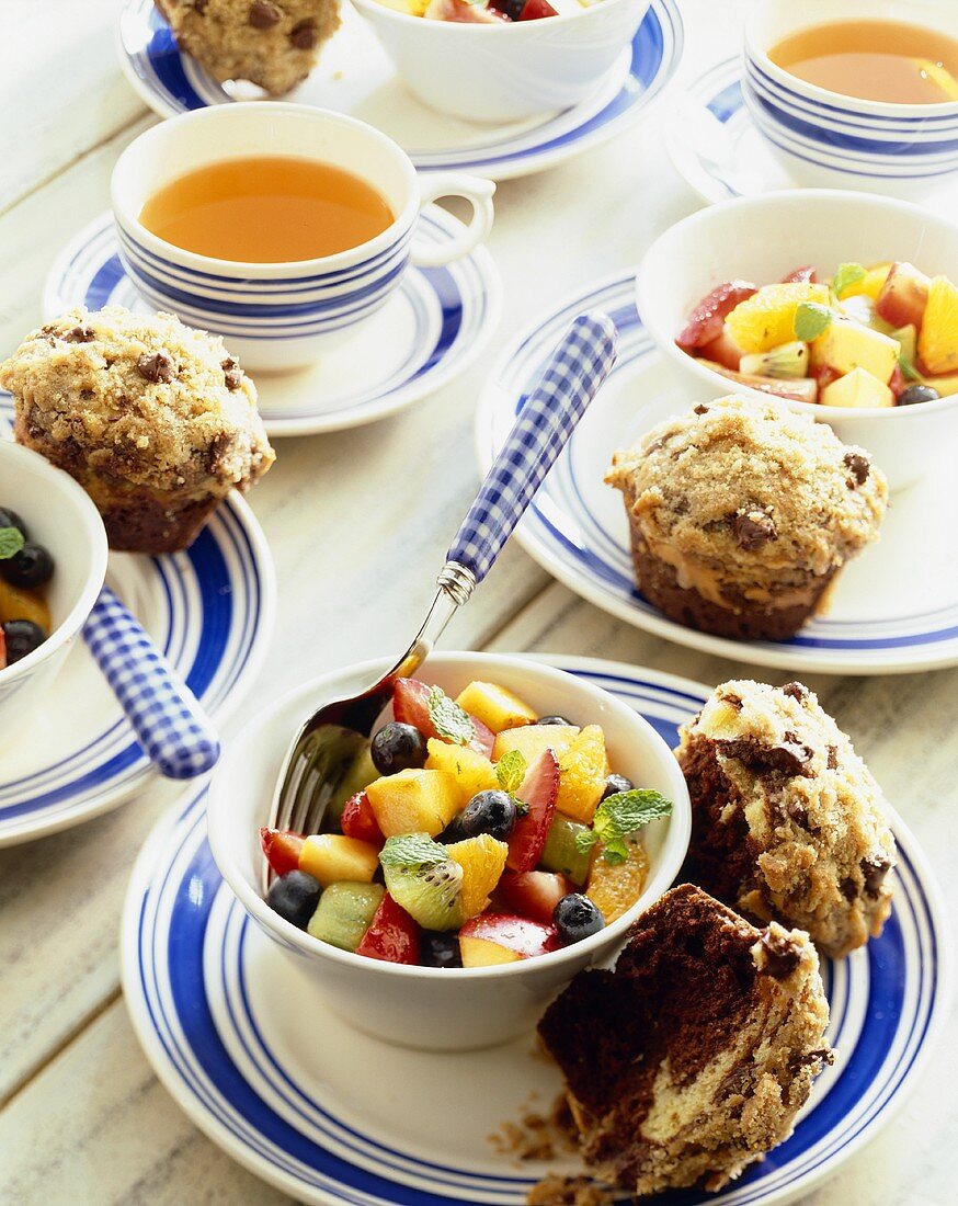 Servings of Fruit Salad with Chocolate Muffins; Cup of Tea