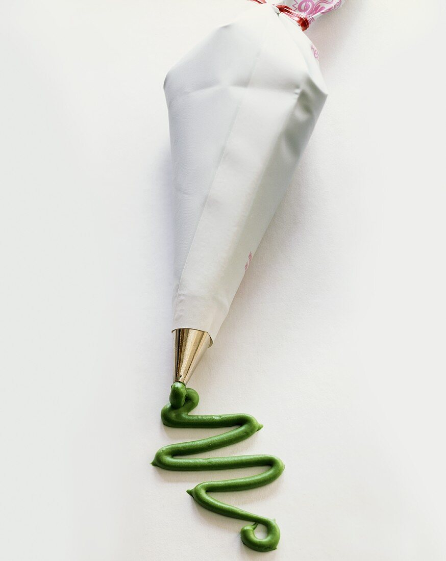 Green Icing Squeezed From a Piping Bag on a White Background