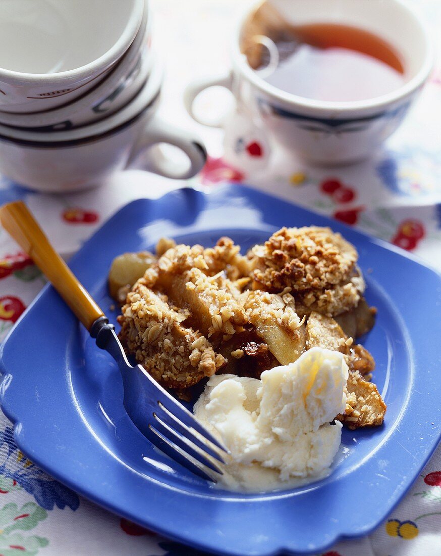 Serving of Apple Crisp with Vanilla Ice Cream; Cup of Tea