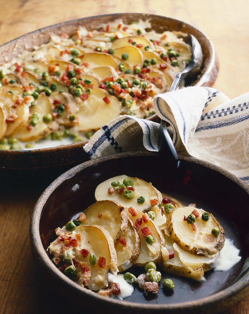 Scalloped Potatoes with Peas and Bacon in Serving Dish and Bowl