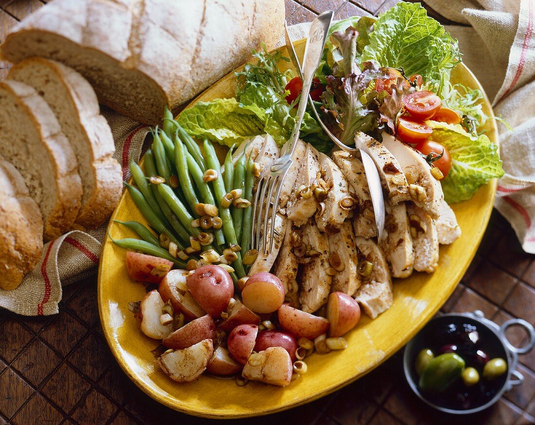 Sliced Chicken with Red Potatoes, Green Beans and a Salad On a Platter