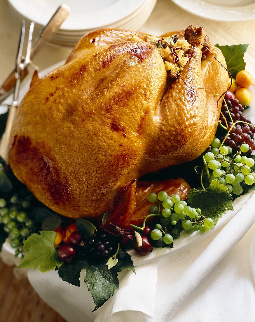 Stuffed Roast Turkey on a Platter with Red and Green Grapes