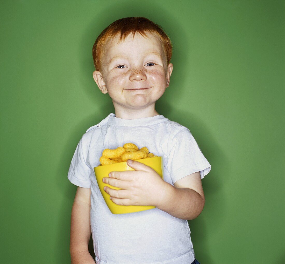Kleiner Junge hält Schale mit Erdnussflips