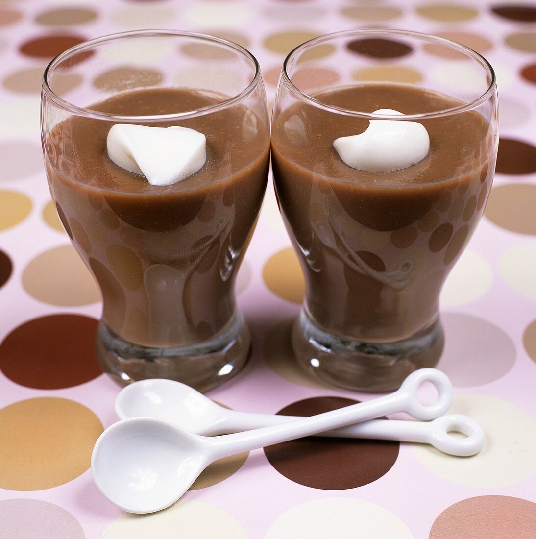 Zwei Gläser Schokoladenpudding mit Sahneklecks