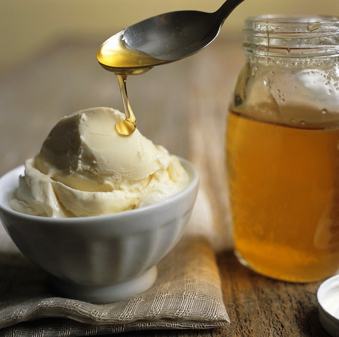 Spooning Honey Over a Bowl of Vanilla Ice Cream