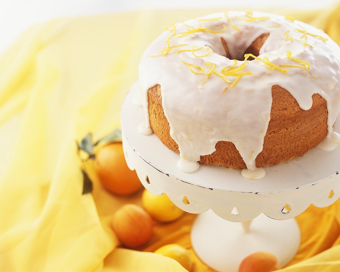 Napfkuchen mit Orangenglasur auf Kuchenständer