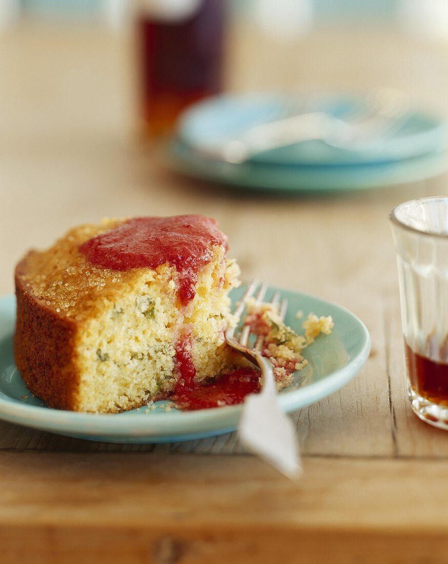 Stück Orangenkuchen mit Limettenzesten und Himbeersauce