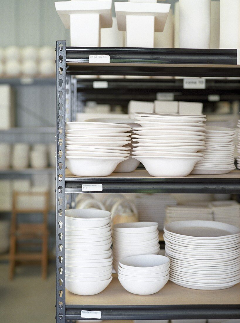 Stacked White Ceramic Dishware on Shelves