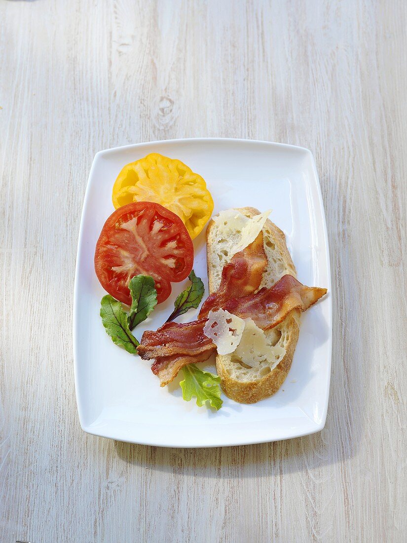 Brot mit Frühstücksspeck, Käsespäne und Tomatenscheiben