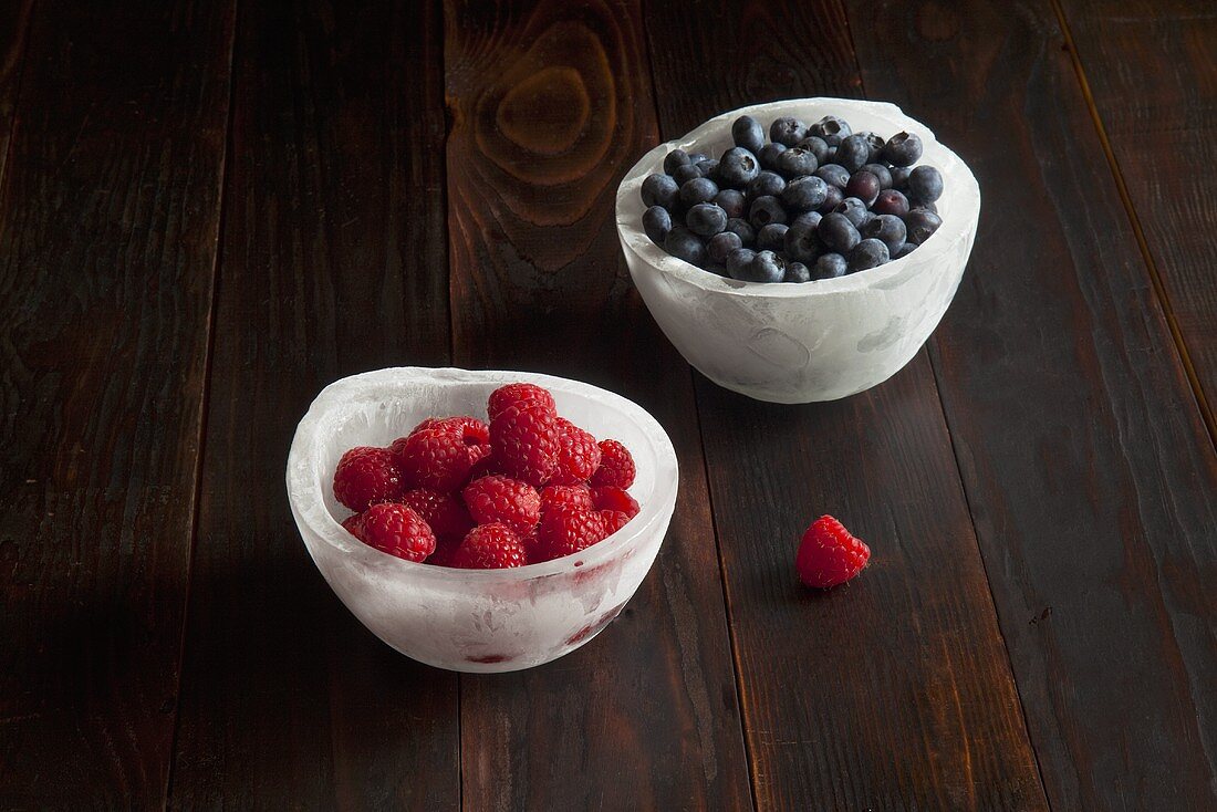 Two Ice Bowls; One with Raspberries; One with Blueberries
