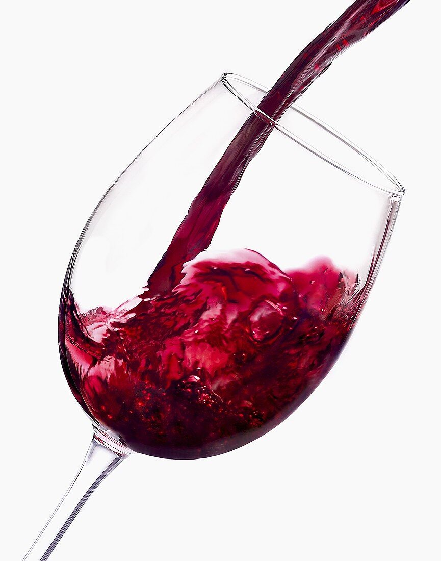 Red Wine Pouring into a Glass on White Background
