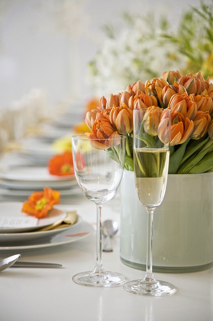 Frühlingshaft gedeckter Tisch mit orangefarbenen Tulpen