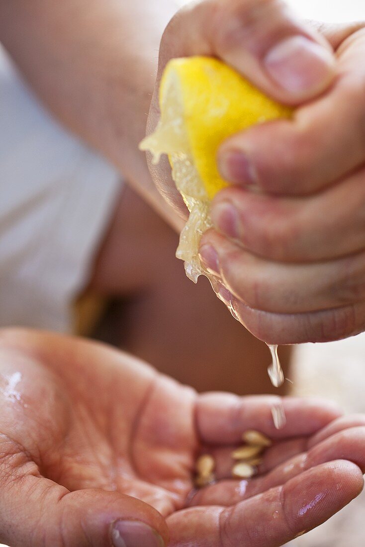 Hände pressen Zitrone aus